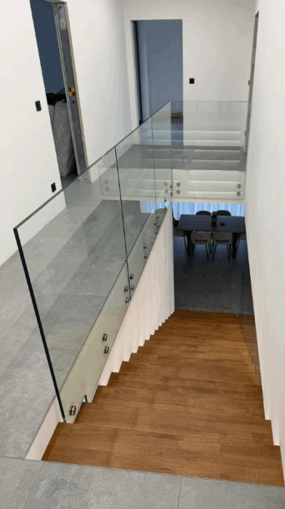 Dřevěný obklad schodiště s celoskleněným zábradlím